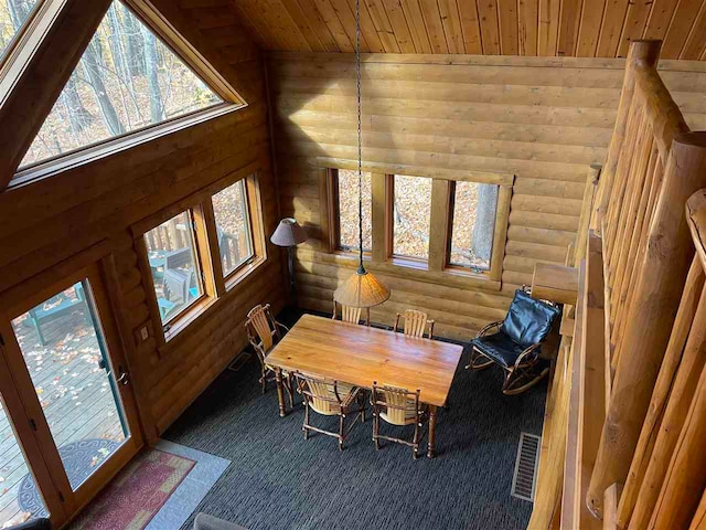 dining room with vaulted ceiling, dark colored carpet, a healthy amount of sunlight, and wooden ceiling