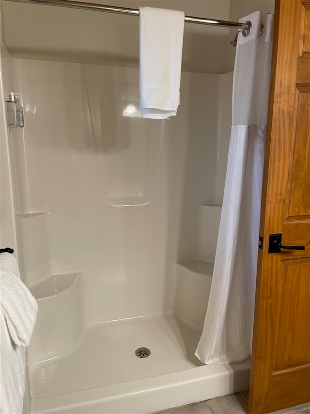 bathroom with a shower with shower curtain and tile patterned flooring