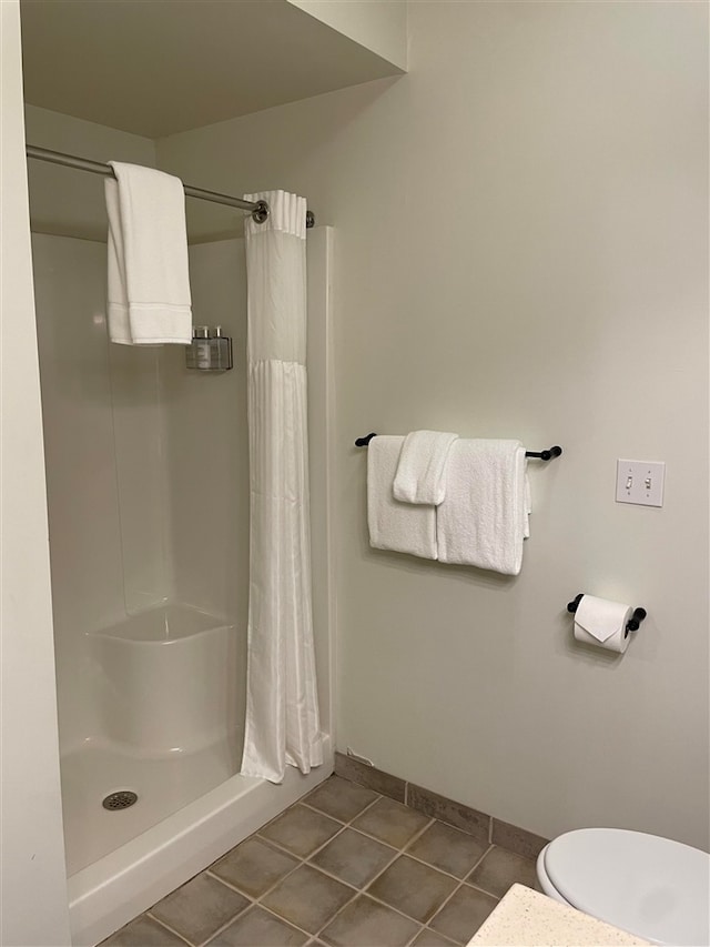 bathroom with tile patterned floors, toilet, and walk in shower