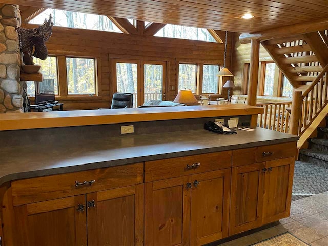 kitchen featuring a wealth of natural light, lofted ceiling, hanging light fixtures, and wooden ceiling