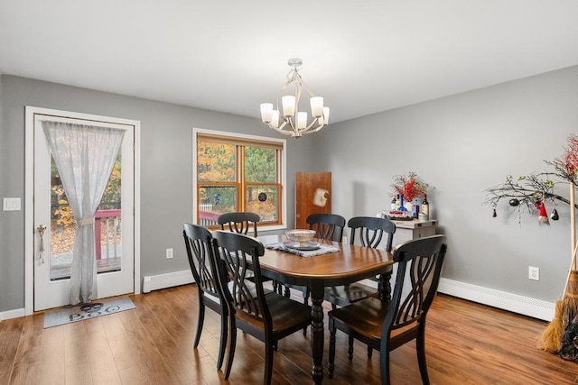 dining area with a notable chandelier, wood-type flooring, and a baseboard radiator