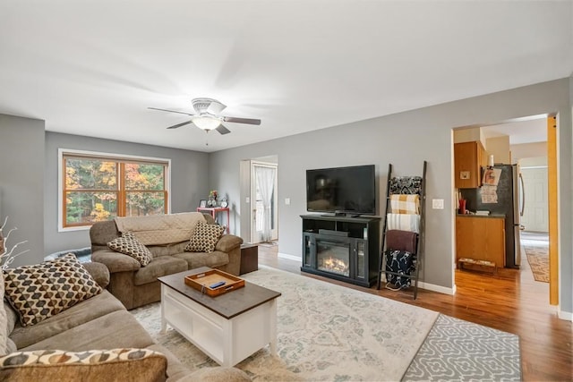 living room featuring light hardwood / wood-style floors and ceiling fan