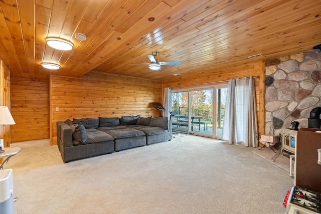 living room featuring light carpet, a wood stove, wooden walls, and wooden ceiling