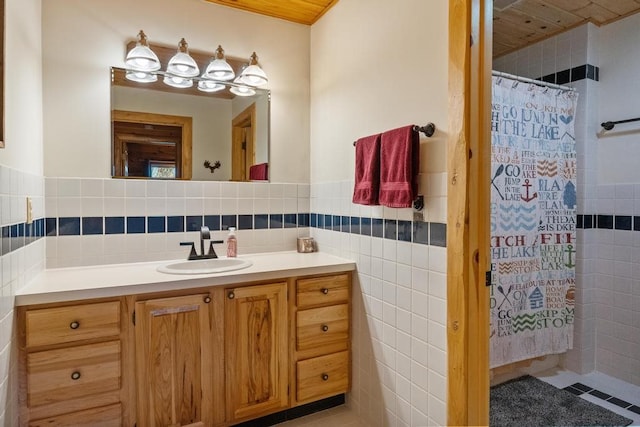 bathroom with tile walls, vanity, a shower with shower curtain, and tile patterned flooring