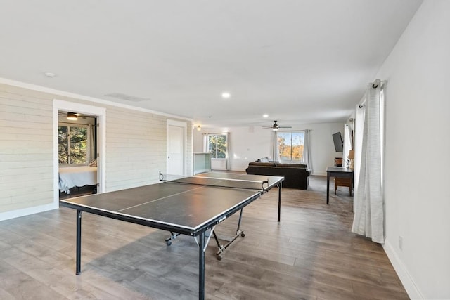 rec room featuring brick wall and hardwood / wood-style floors