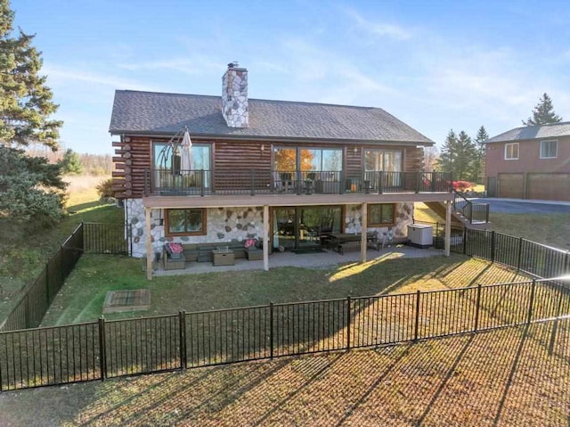 rear view of house with a patio, an outdoor living space, and a yard