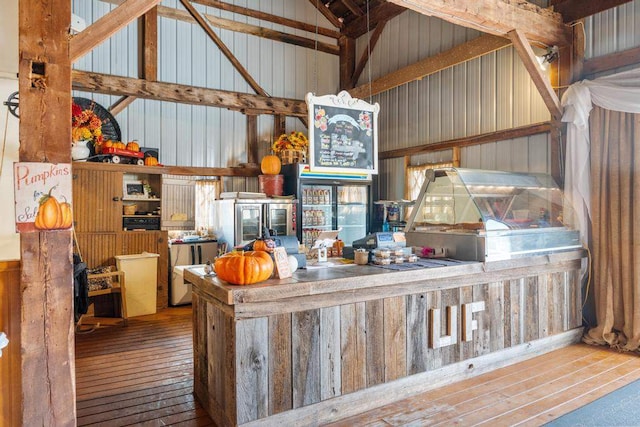 kitchen featuring beam ceiling, wood walls, high vaulted ceiling, and hardwood / wood-style floors