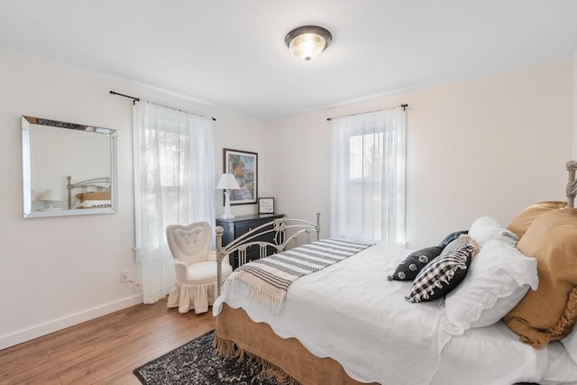 bedroom with hardwood / wood-style floors and multiple windows