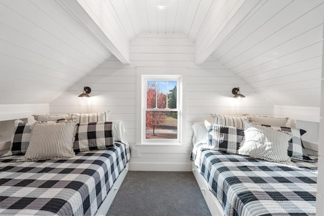 bedroom with dark carpet, wooden walls, and lofted ceiling with beams