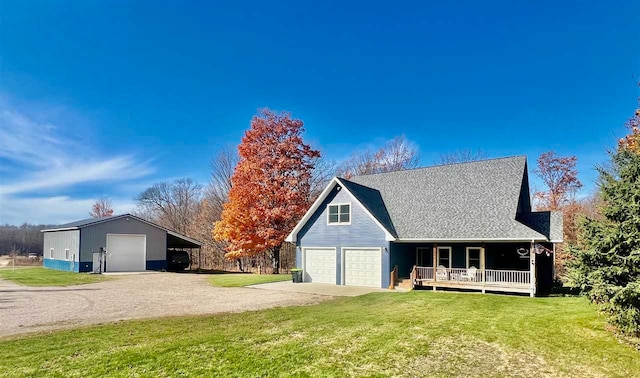 view of front of house featuring covered porch, a garage, and a front lawn