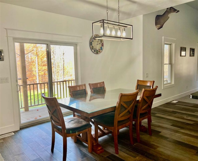 dining area with a wealth of natural light and dark wood-type flooring