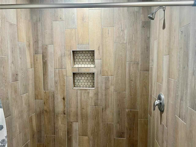 interior details featuring a tile shower