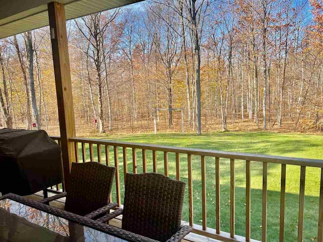 wooden terrace featuring grilling area and a yard