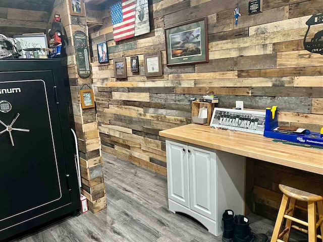 bar with wood counters, hardwood / wood-style flooring, white cabinetry, and wood walls