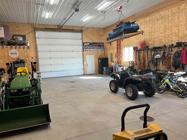 garage featuring a garage door opener and wooden walls