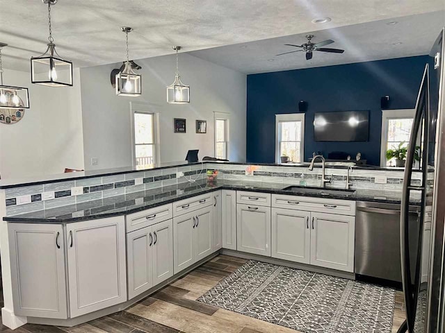 kitchen with dark stone counters, white cabinetry, dark wood-type flooring, and decorative light fixtures