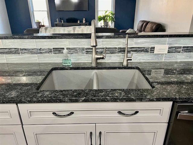 kitchen with sink, white cabinets, and dark stone counters