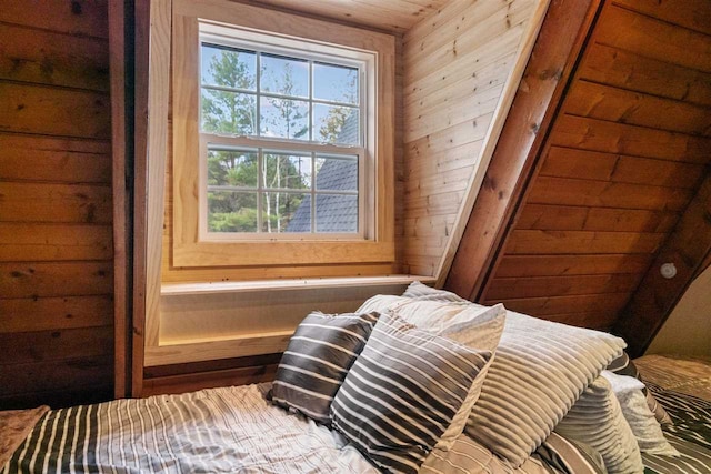 bedroom with wooden walls and vaulted ceiling