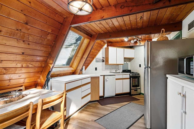 kitchen with appliances with stainless steel finishes, wood ceiling, white cabinetry, and vaulted ceiling with beams