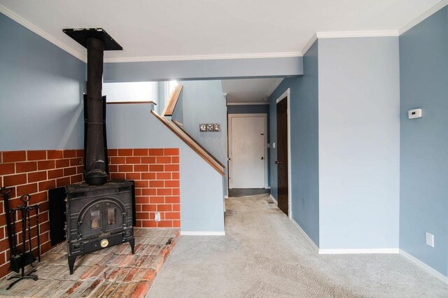 1185 Hideaway Valley Dr Unit 5, Harbor Springs, MI 49740 - unfurnished living room with a wood stove, crown molding, baseboards, carpet flooring, and stairway