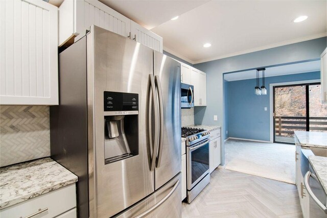 1185 Hideaway Valley Dr Unit 5, Harbor Springs, MI 49740 - kitchen featuring appliances with stainless steel finishes, light stone counters, ornamental molding, pendant lighting, and white cabinets