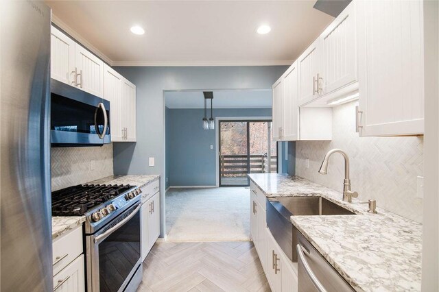 1185 Hideaway Valley Dr Unit 5, Harbor Springs, MI 49740 - kitchen with stainless steel appliances, baseboards, light stone countertops, white cabinetry, and decorative backsplash