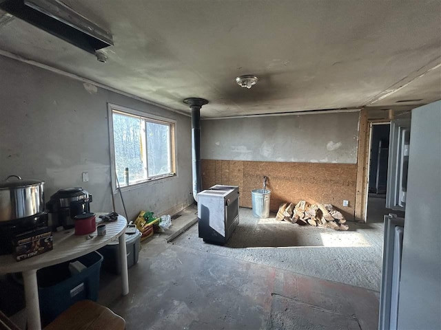 5157 Graham Rd, East Jordan, MI 49727 - miscellaneous room featuring a wood stove and unfinished concrete flooring