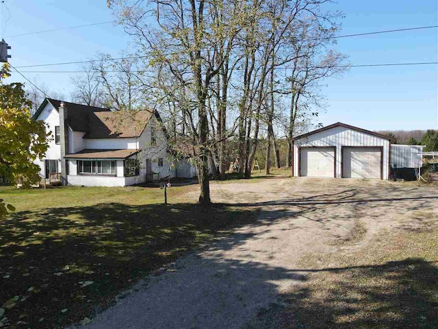 view of side of property with an outdoor structure, a garage, and a lawn