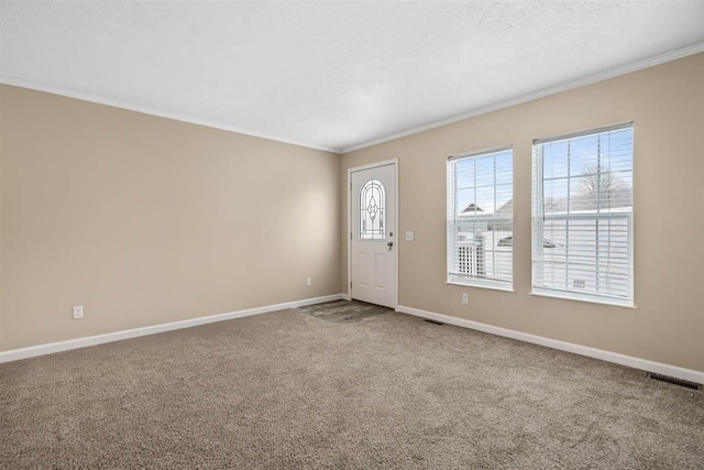 carpeted entryway featuring baseboards, visible vents, and crown molding