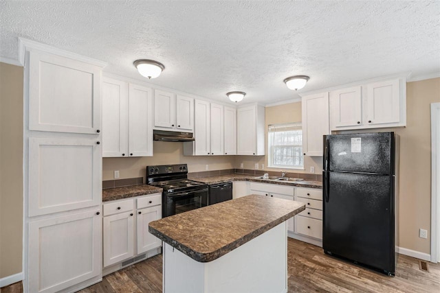kitchen featuring white cabinetry, black appliances, dark countertops, and a sink