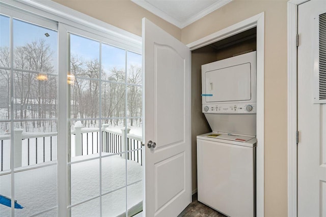 clothes washing area with ornamental molding, laundry area, and stacked washer / drying machine