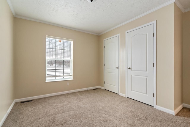 3911 Leslie Ln, Petoskey, MI 49770 - unfurnished bedroom with a textured ceiling, visible vents, crown molding, carpet flooring, and baseboards