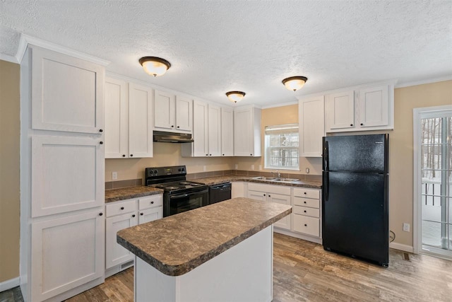 3911 Leslie Ln, Petoskey, MI 49770 - kitchen with a sink, black appliances, under cabinet range hood, dark countertops, and light wood-style floors