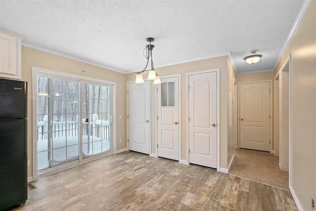 3911 Leslie Ln, Petoskey, MI 49770 - unfurnished dining area featuring light wood-style floors, baseboards, ornamental molding, and a textured ceiling