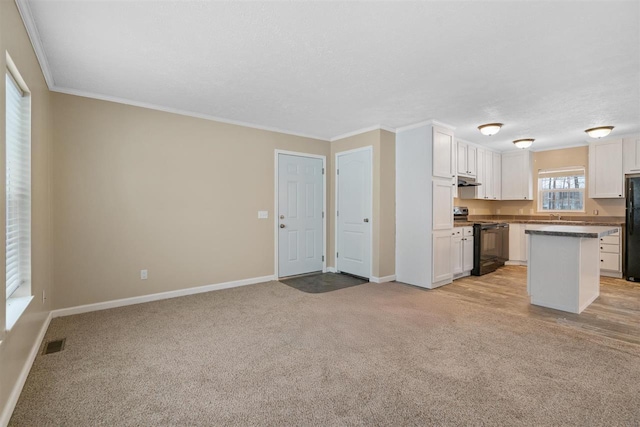 3911 Leslie Ln, Petoskey, MI 49770 - kitchen featuring white cabinetry, black appliances, visible vents, and light colored carpet