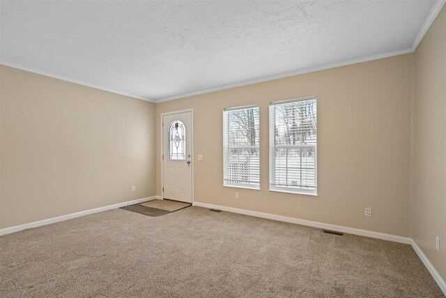 3911 Leslie Ln, Petoskey, MI 49770 - carpeted foyer featuring a textured ceiling, visible vents, baseboards, and ornamental molding