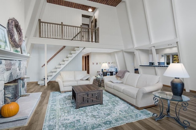 living room featuring a fireplace, a high ceiling, and hardwood / wood-style floors