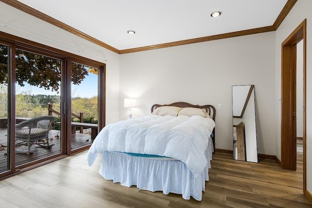 bedroom with hardwood / wood-style floors, ornamental molding, and access to exterior