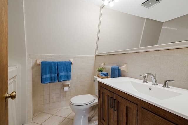 bathroom featuring vanity, tile patterned flooring, toilet, and tile walls