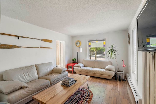 living room with a textured ceiling, light hardwood / wood-style floors, and a baseboard heating unit