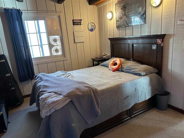 carpeted bedroom featuring wood walls