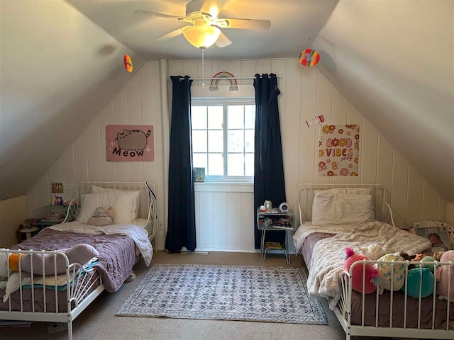 carpeted bedroom with wood walls, lofted ceiling, and ceiling fan