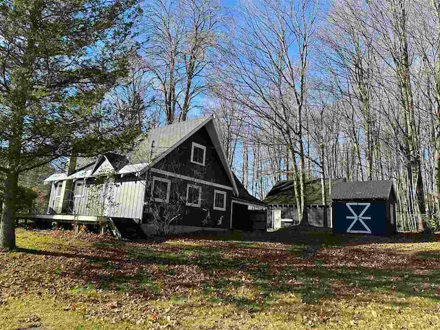 back of property featuring an outdoor structure