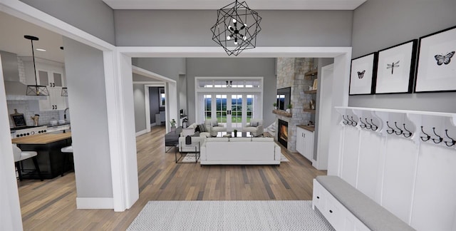 entryway featuring a large fireplace, wood-type flooring, and a chandelier