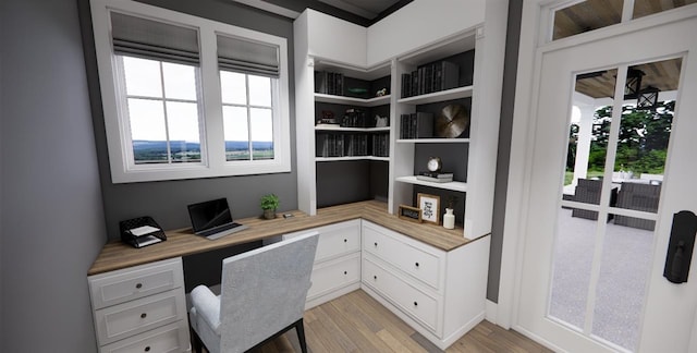 office area featuring a wealth of natural light, built in desk, and light hardwood / wood-style flooring