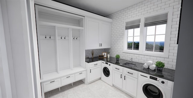 clothes washing area featuring washer / clothes dryer, cabinets, and sink