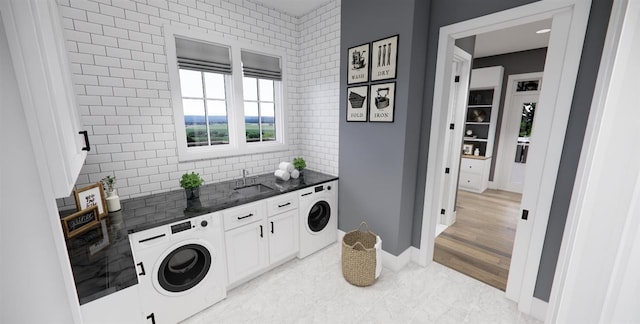 laundry room featuring light hardwood / wood-style flooring, cabinets, sink, and washer / dryer