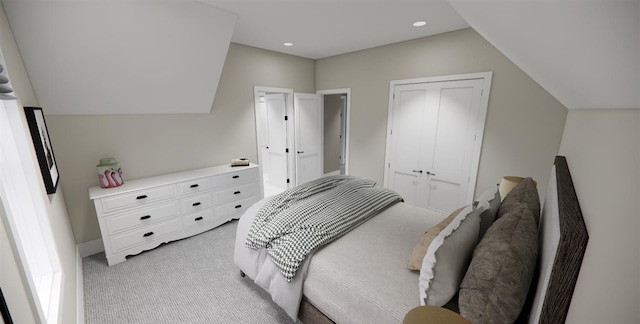 bedroom featuring light colored carpet, lofted ceiling, and a closet