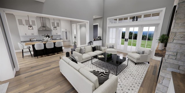 living room featuring a high ceiling, light wood-type flooring, and french doors