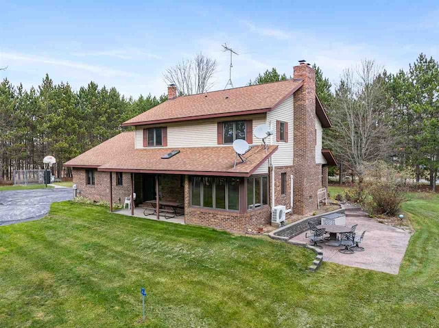 back of house featuring a lawn and a patio